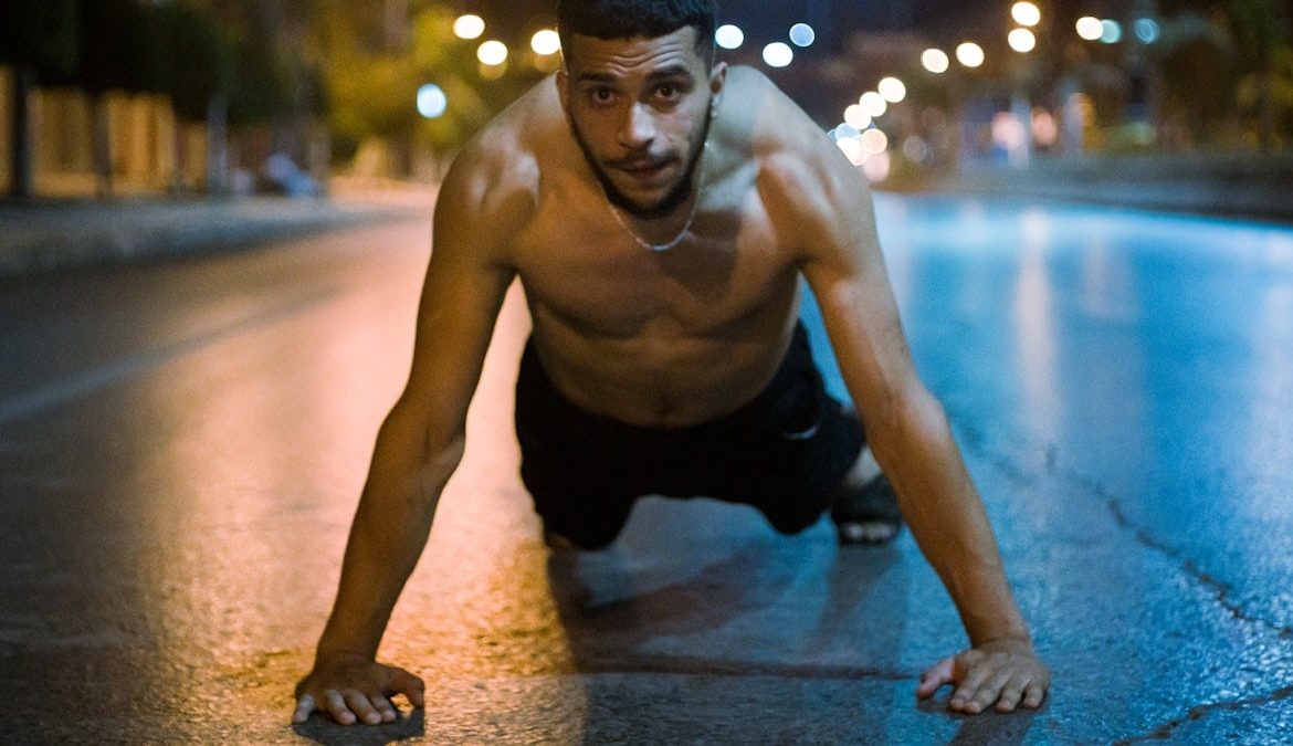 topless man in black shorts kneeling on floor